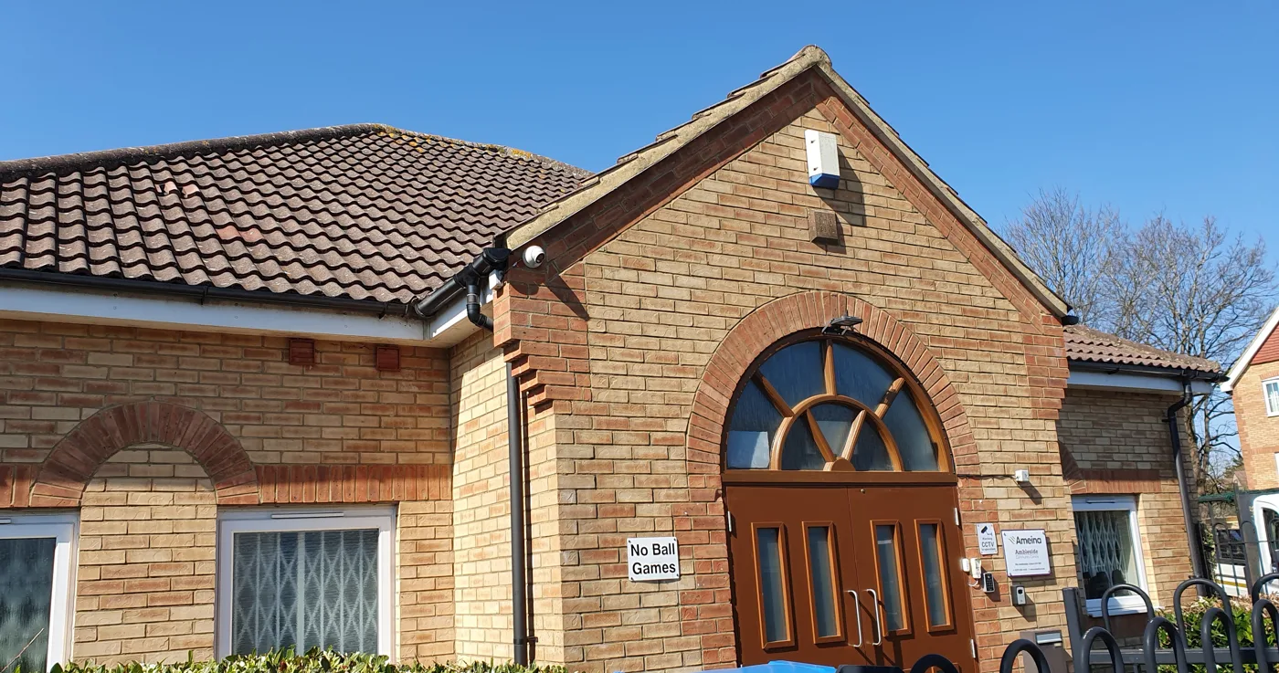 The Ameina Centre in Ambleside, Luton: a single-storey brick building with a tiled roof and an arched wooden double door