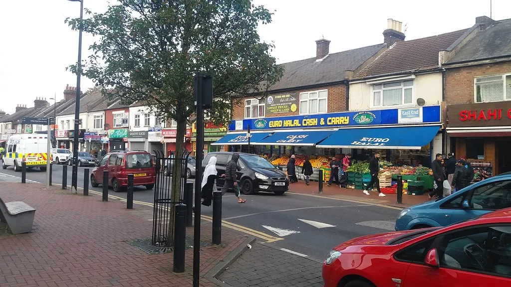 Shops and kerbside parking on Dunstable Road in Bury Park, photographed in 2017. The photograph predates the red route proposals.
