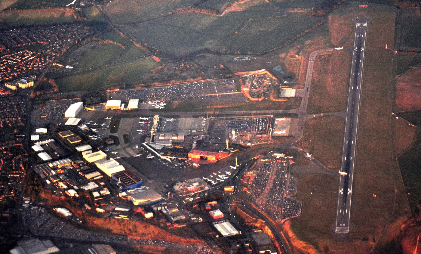 London Luton Airport from the air, with the runway on the right and homes on the edge of Luton on the left.